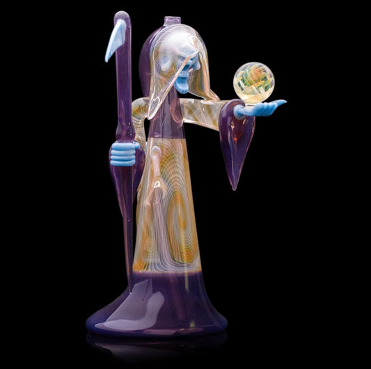 Decorative glass sculpture of a reaper holding a scythe and crystal ball.