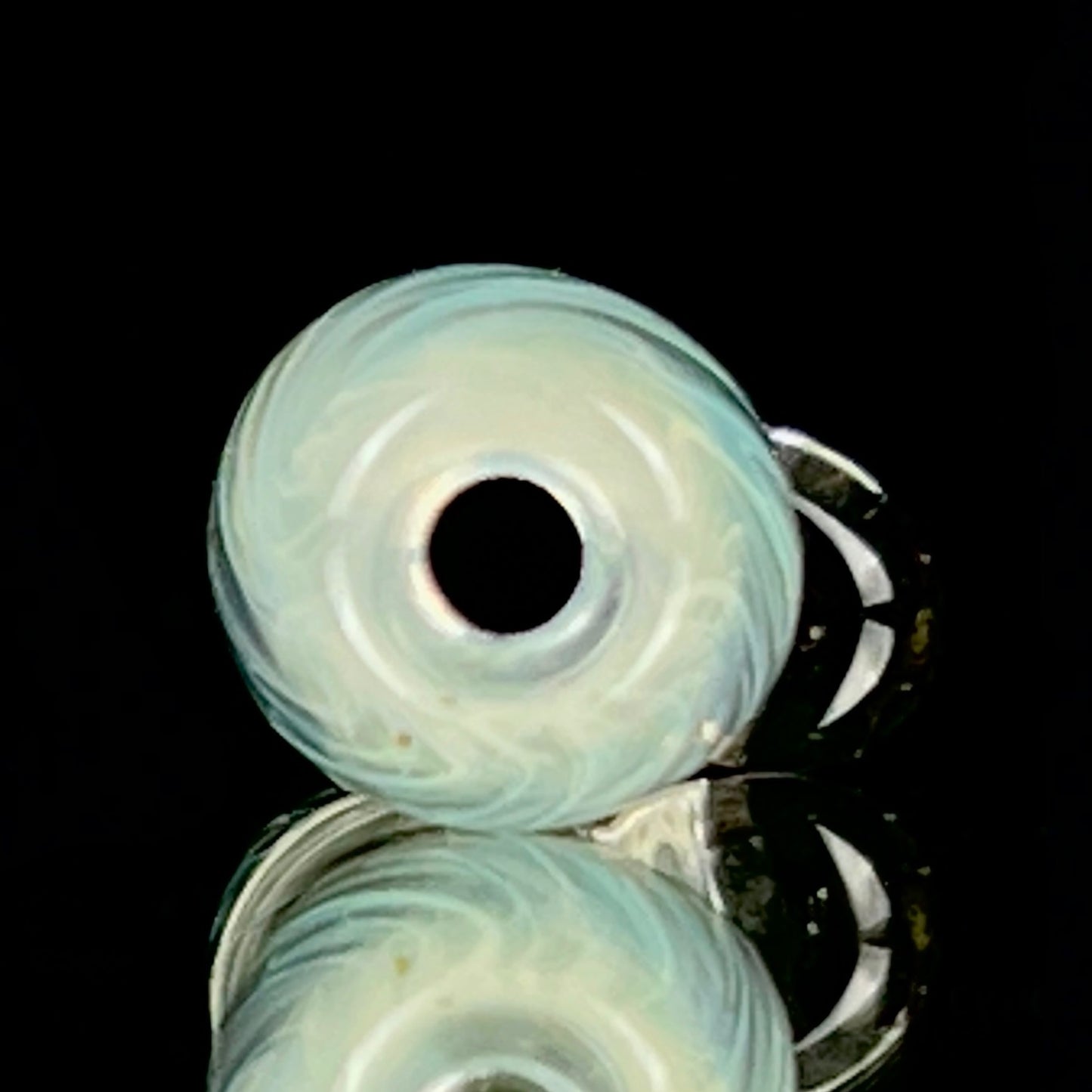 A glass fume tip with swirls of color, primarily clear with blue patterns, designed for use with larger rolls.