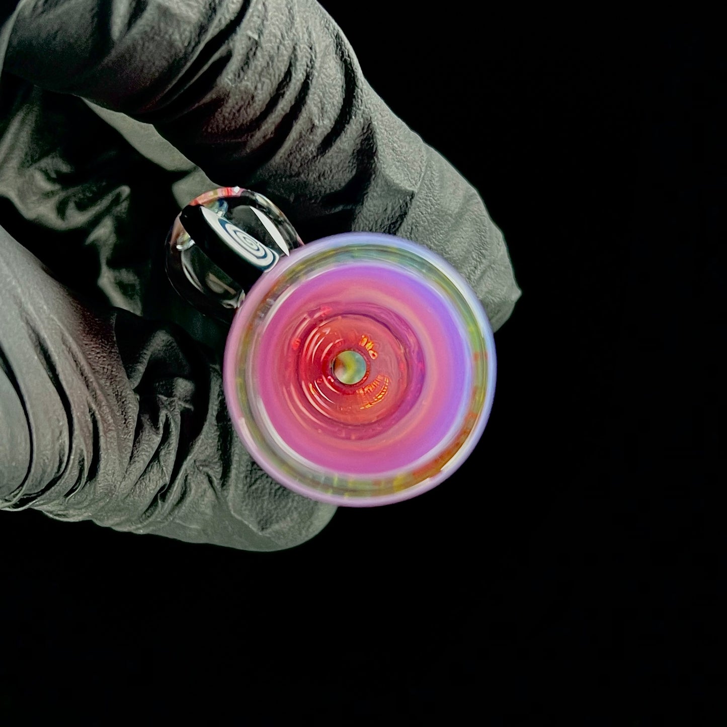 A multicolored glass piece with an intricate pattern, featuring a bowl on the bottom and a Gold Ruby over Moonstone lip.