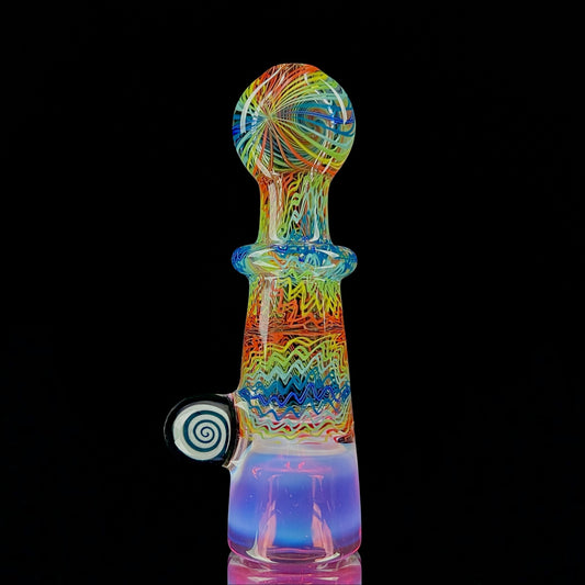 A multicolored glass piece with an intricate pattern, featuring a bowl on the bottom and a Gold Ruby over Moonstone lip.