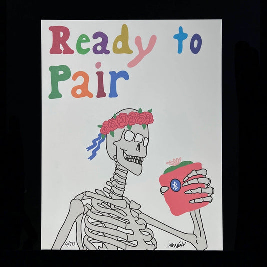 A framed print featuring a cartoon skeleton with a lei, holding a heart, with the text 'Ready to Pair' above.