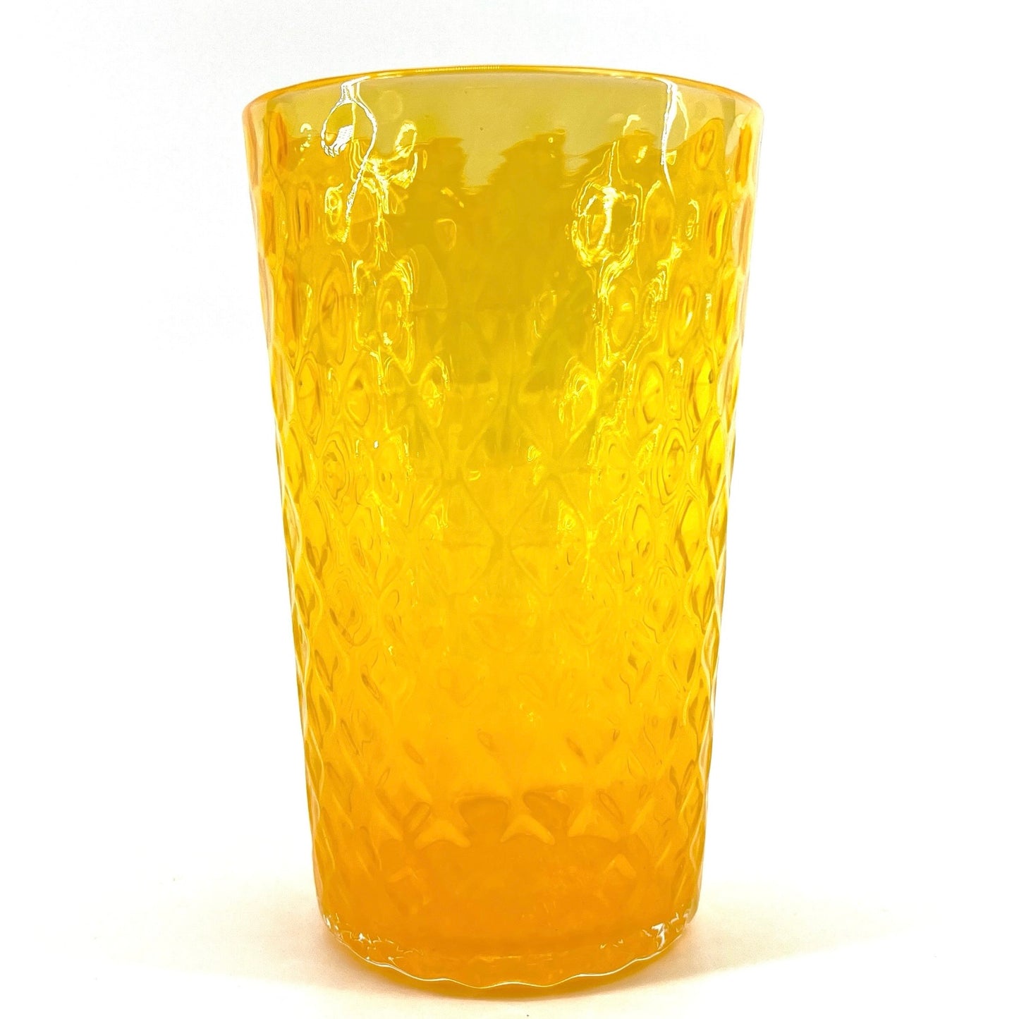 A yellow colored glass with a geometric optic pattern.