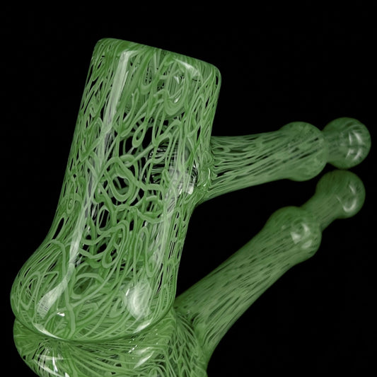 A jade green glass hand pipe with intricate patterns.