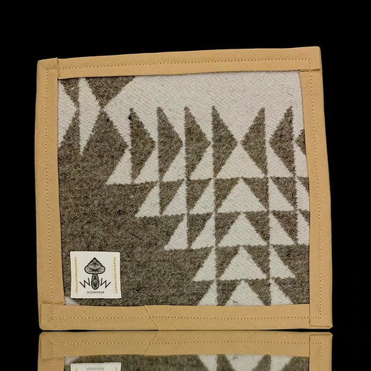 A rectangular Pendleton mat with a geometric pattern in beige and gray colors, featuring the Wook Wear logo.