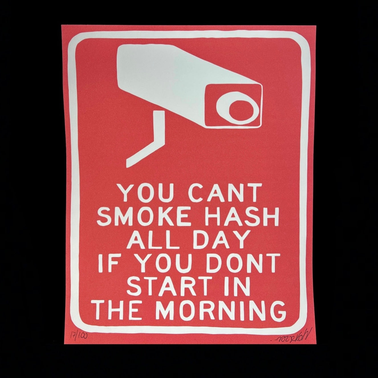A red print with white text and a graphic of a security camera that says 'YOU CAN'T SMOKE HASH ALL DAY IF YOU DON'T START IN THE MORNING'.