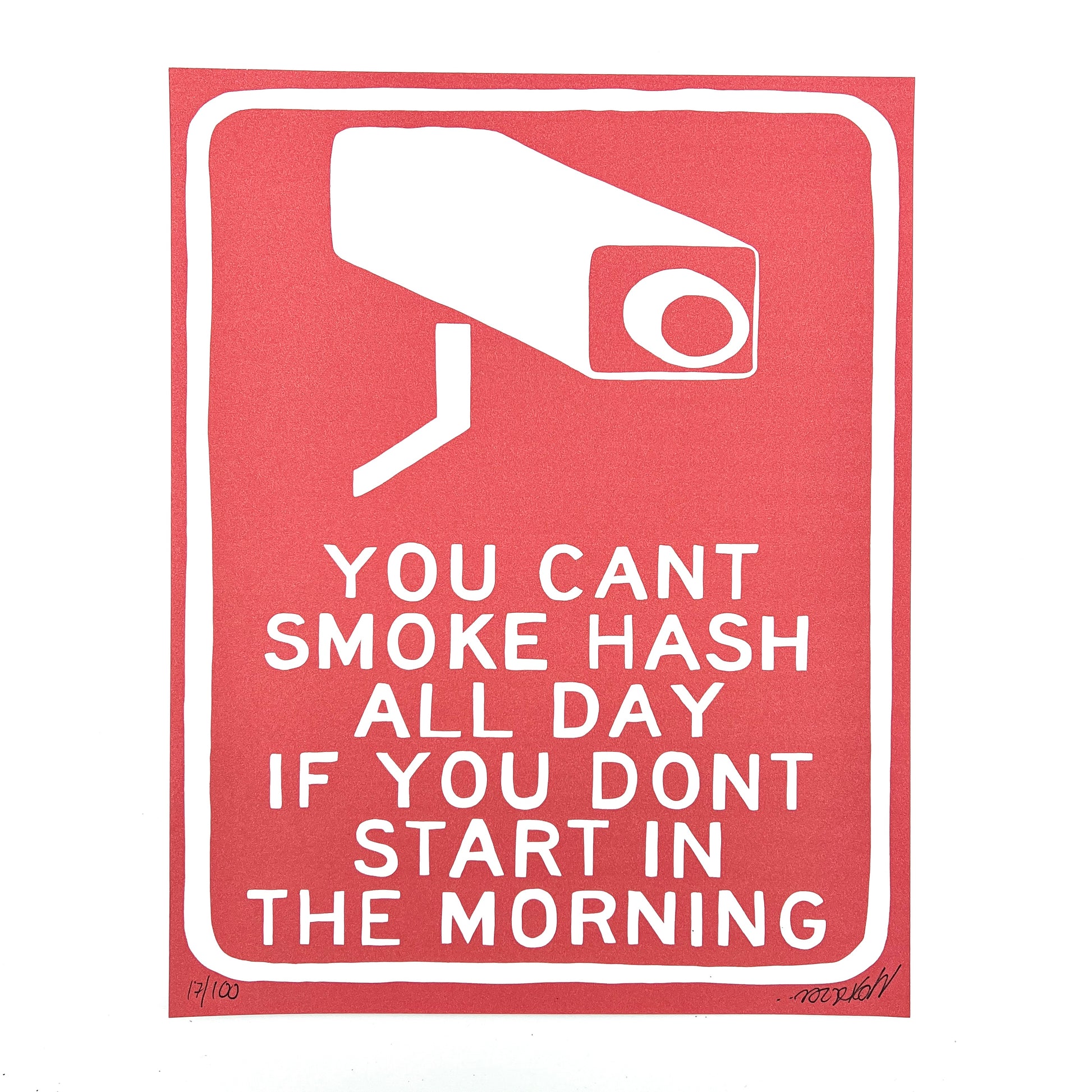 A red print with white text and a graphic of a security camera that says 'YOU CAN'T SMOKE HASH ALL DAY IF YOU DON'T START IN THE MORNING'.