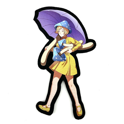 A decorative mat featuring an anime-style character with a purple umbrella and a yellow dress.