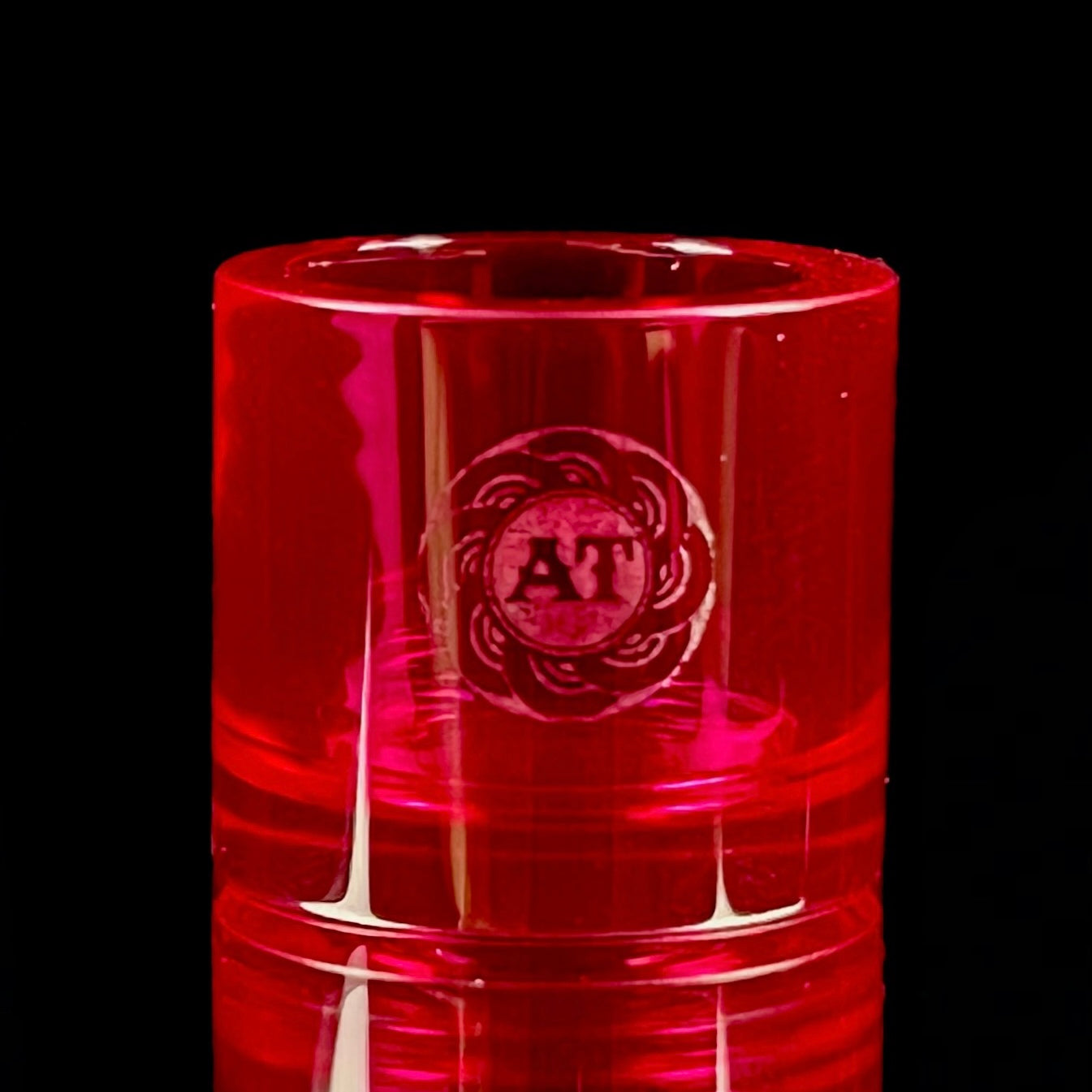 A red-colored, cylindrical Ruby insert with the Adapt Tech logo engraved on the side.