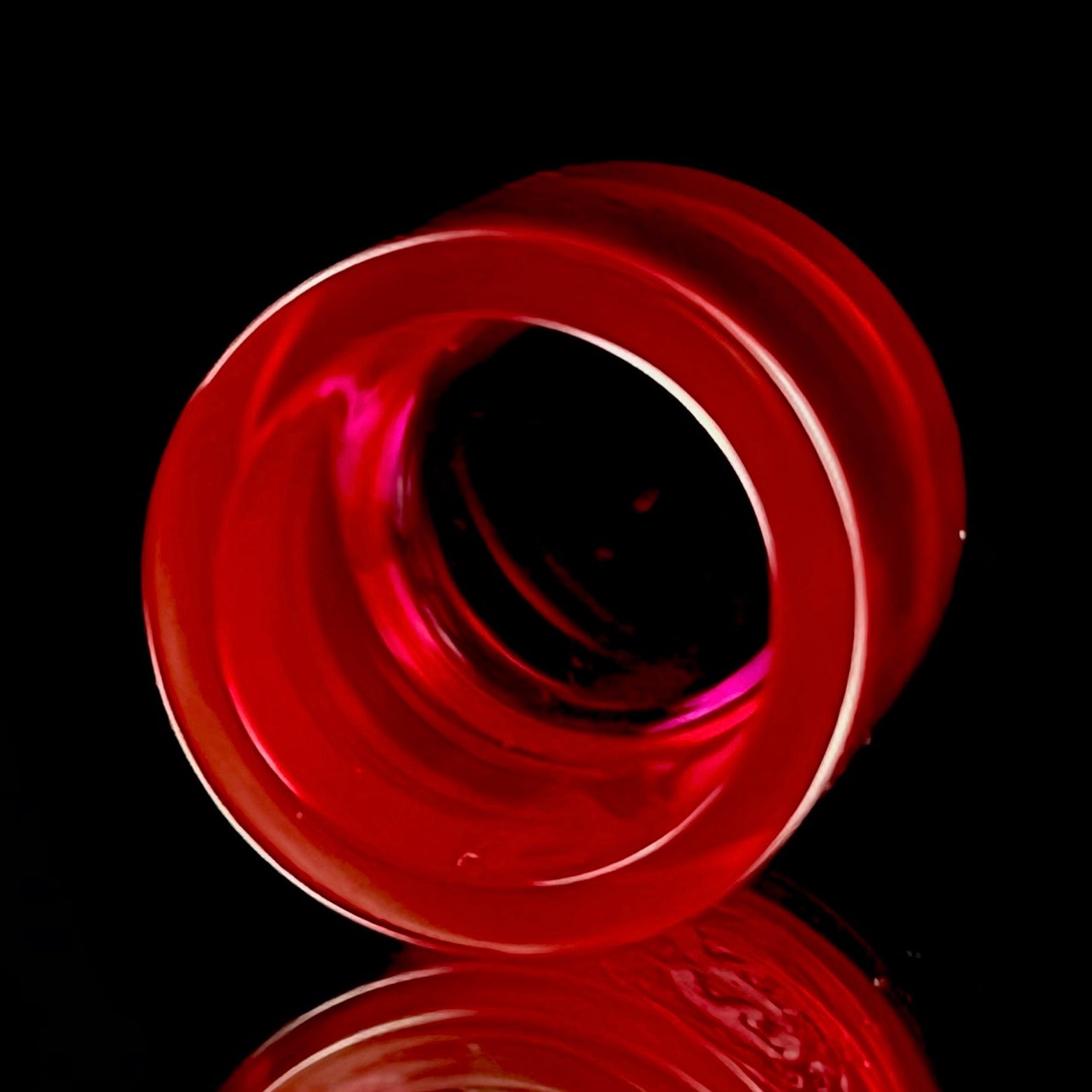 A red-colored, cylindrical Ruby insert with the Adapt Tech logo engraved on the side.