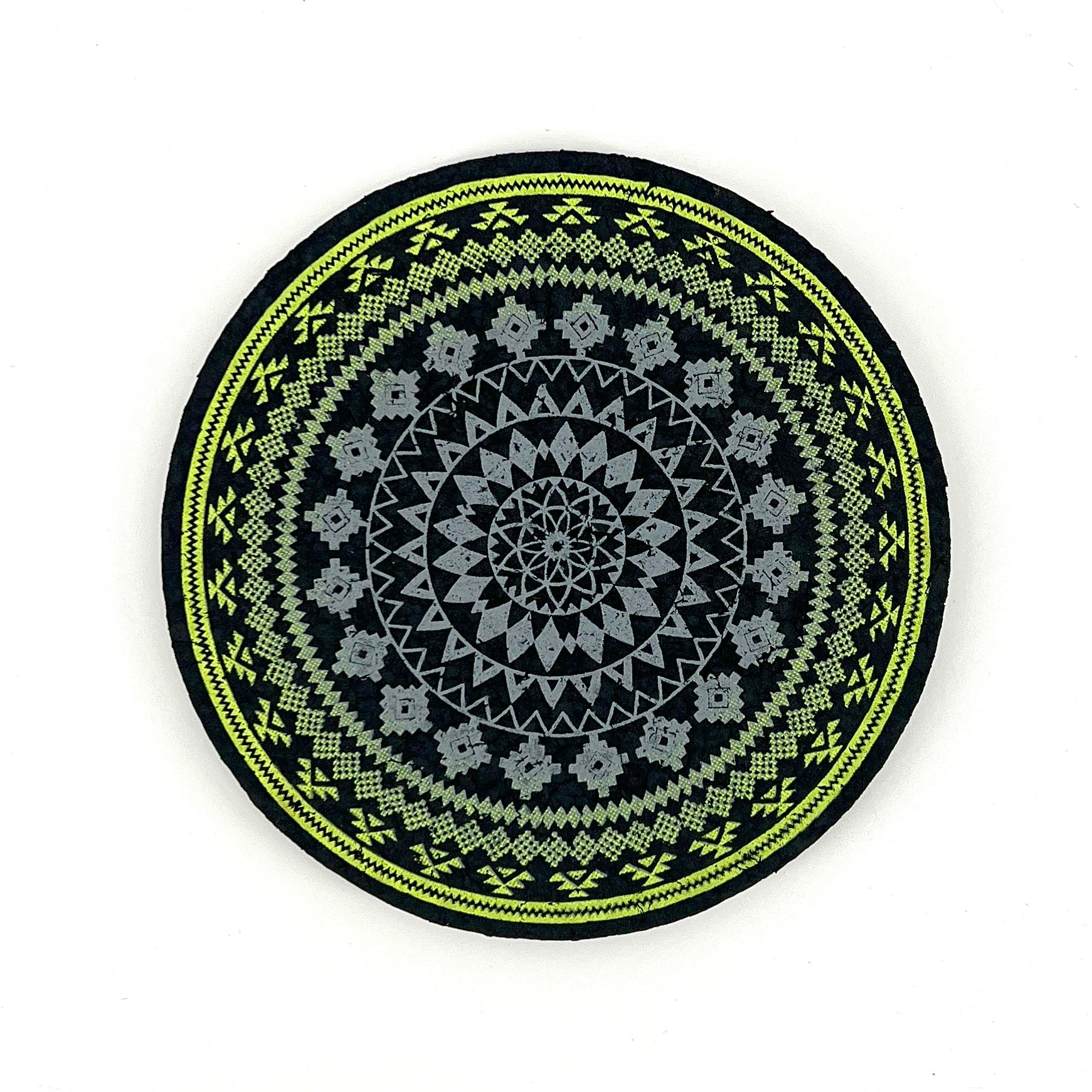 Round black mat with green and gray geometric pattern on a white background