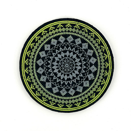 Round black mat with green and gray geometric pattern on a white background