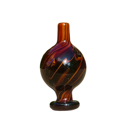 Decorative glass cap with brown and black swirl pattern on a white background.
