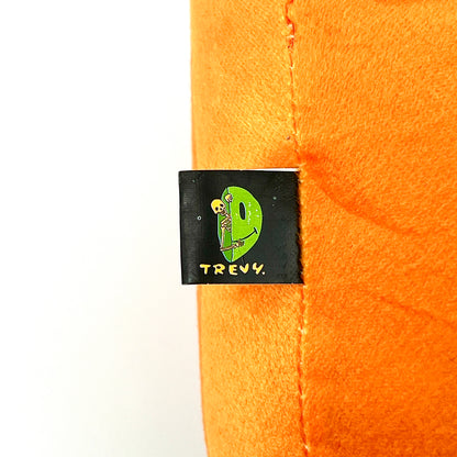 A plush toy designed by Trevy Metal featuring a skeleton peeking out from an orange shell, resembling a pumpkin.