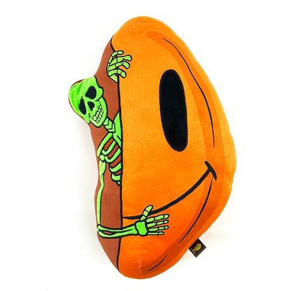 A plush toy designed by Trevy Metal featuring a skeleton peeking out from an orange shell, resembling a pumpkin.