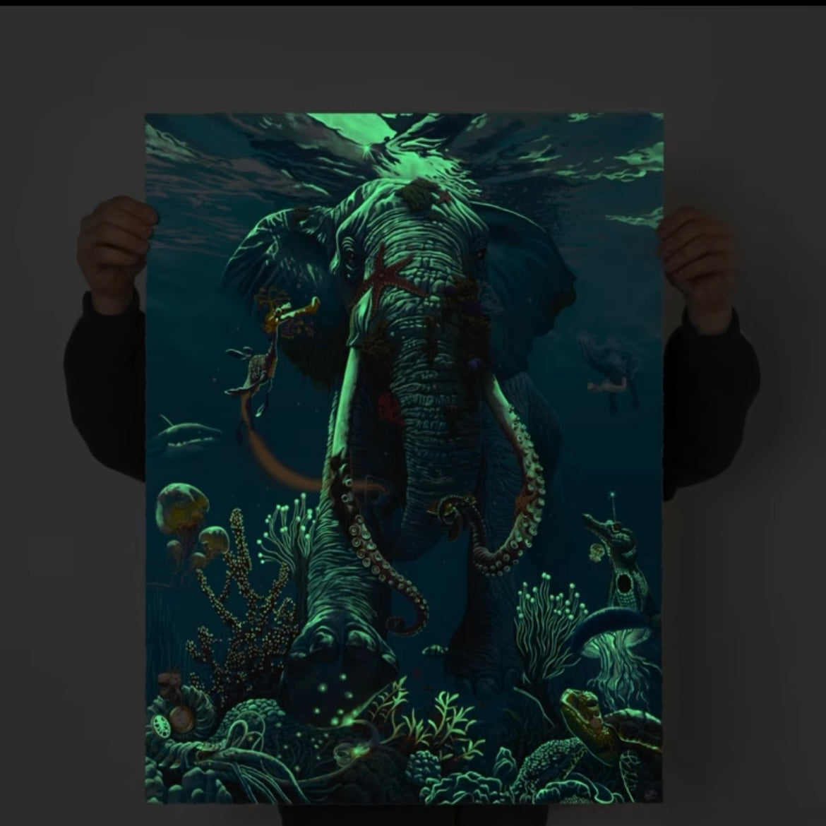 A UV shot of an artistic print depicting a colorful underwater scene with a central elephant figure surrounded by fish and coral.