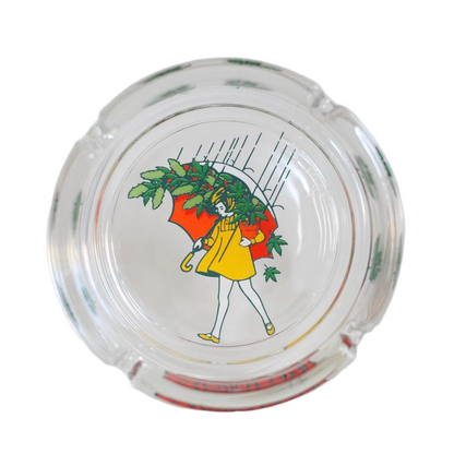 A clear glass ash tray with a cartoon character depicted on the bottom surface.