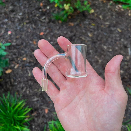 Clear quartz bucket held in a hand with a natural background.