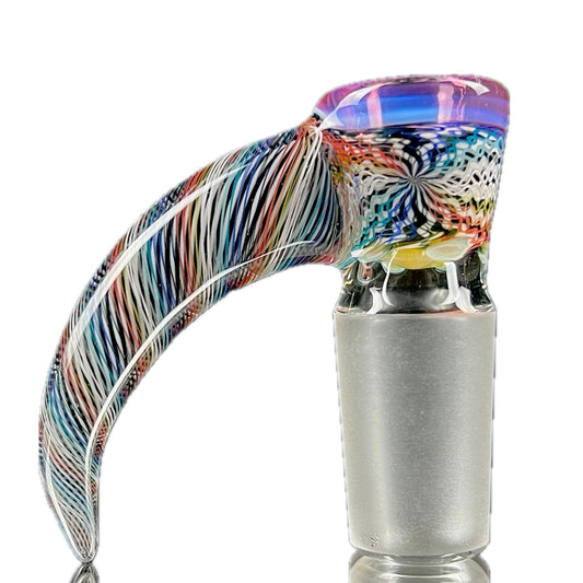 A glass piece with a multicolored, patterned body and a gold lip.
