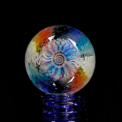 A multicolored glass marble with a swirl pattern, approximately 38mm in diameter.