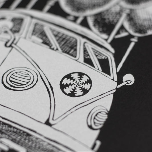 Close-up of a hand screen printed white ink on black paper, depicting a stylized bus.