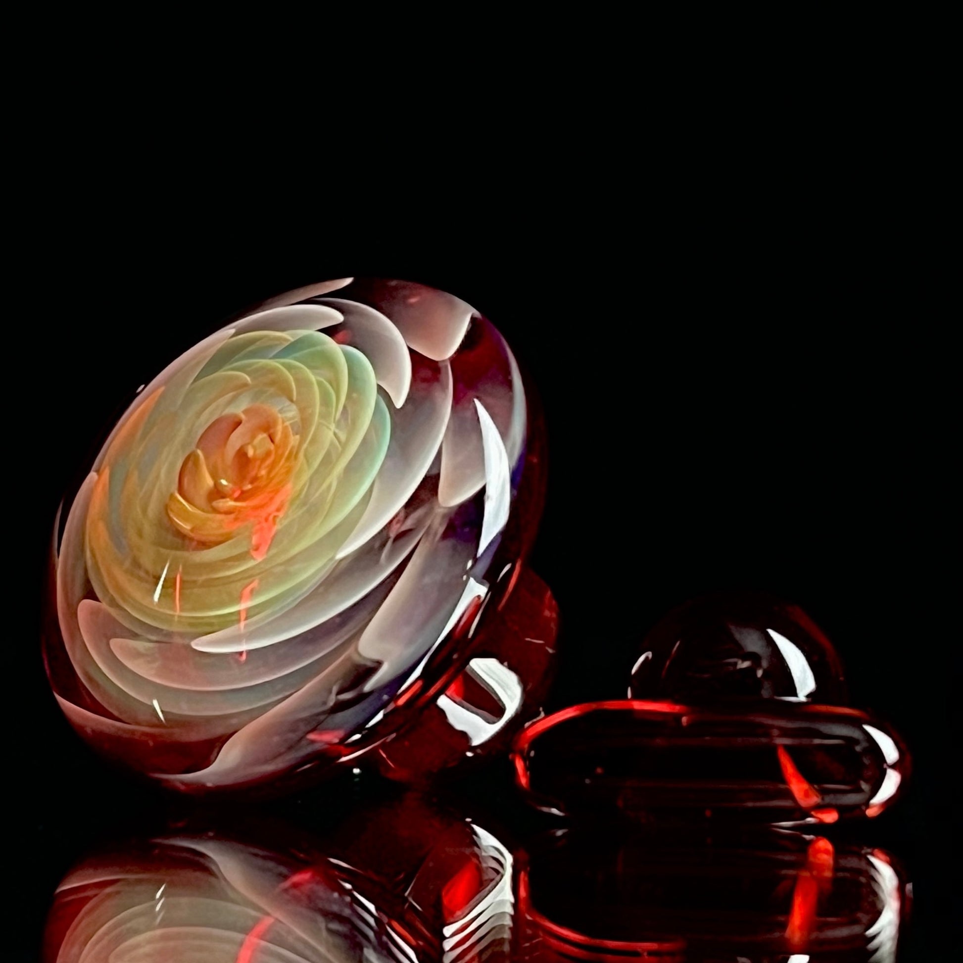 A set of three Phase Glass pieces with a swirling multicolor design, including a cap plug, valve marble, and pillar.