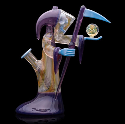 Decorative glass sculpture of a reaper holding a scythe and crystal ball.