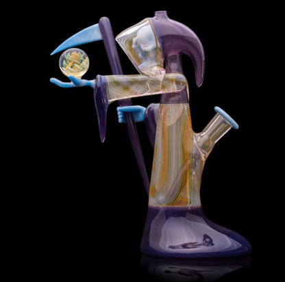 Decorative glass sculpture of a reaper holding a scythe and crystal ball.