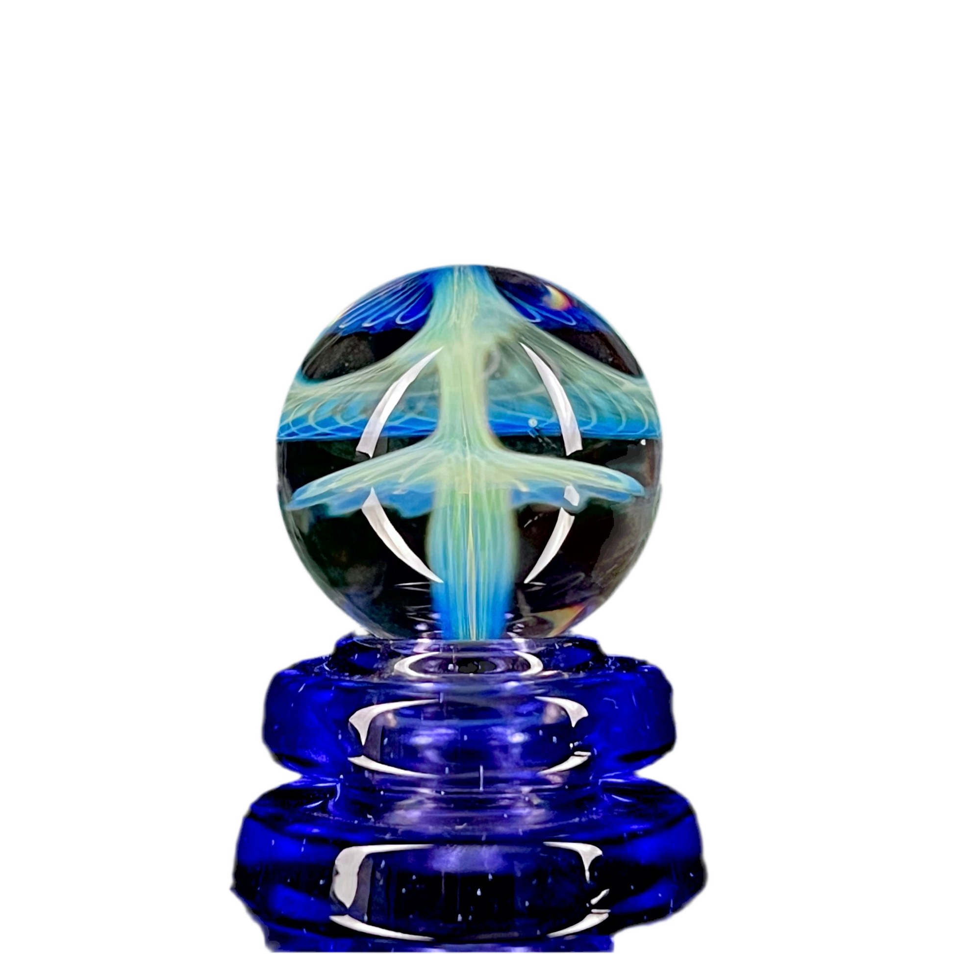 A glass marble with a blue base and a patterned top resembling a shroom or mushroom cloud.