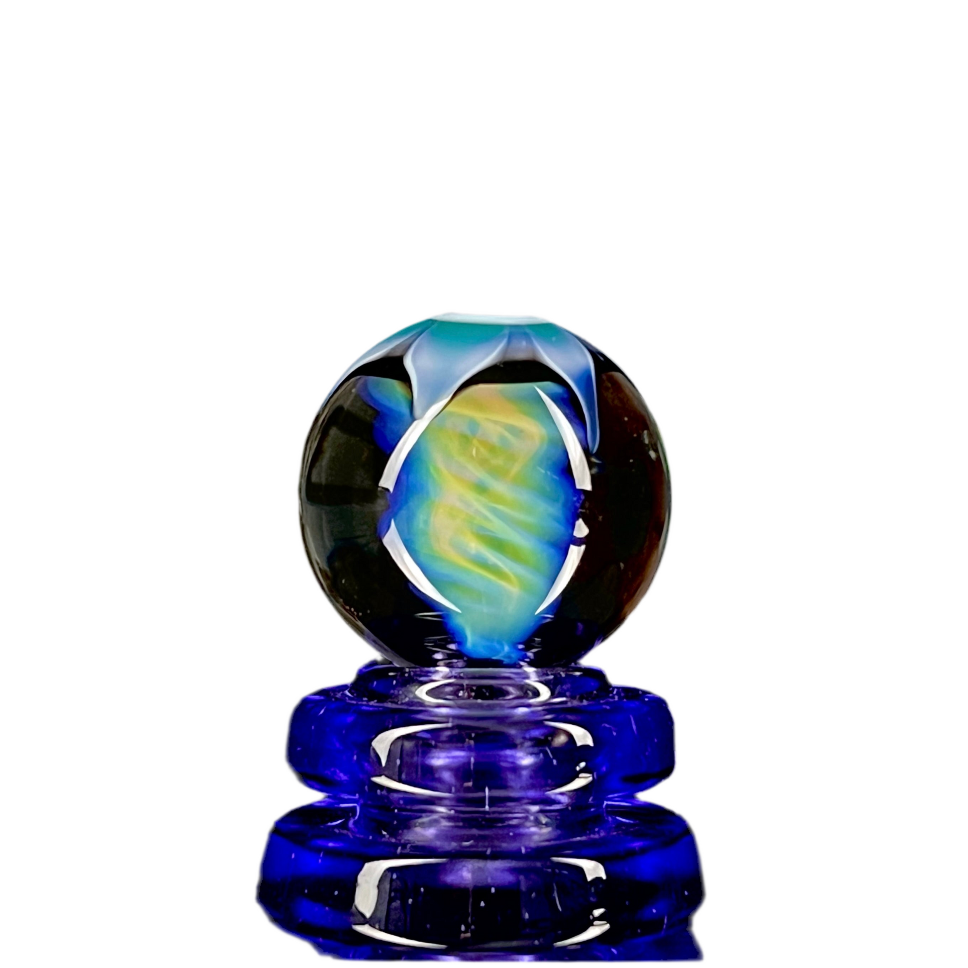 A colorful glass marble with a spiral pattern, predominantly blue and black.