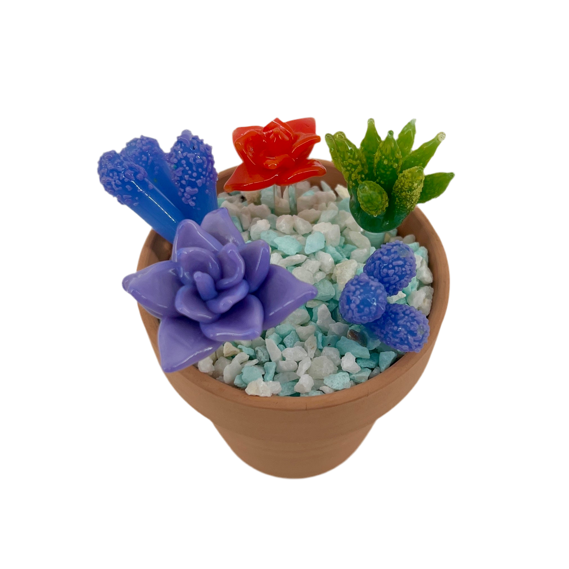 Colorful glass succulents in a pot with decorative stones on a white background.
