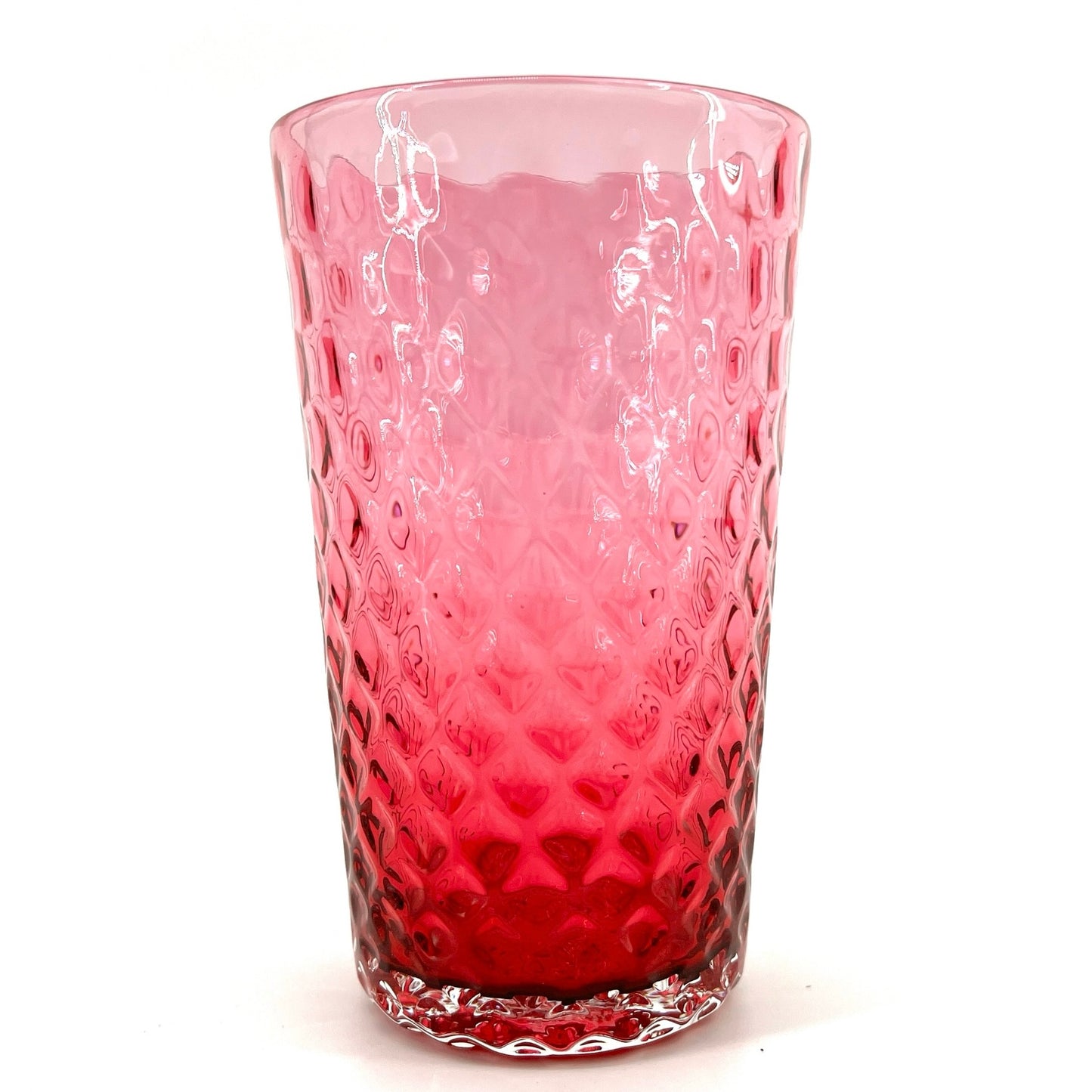A red glass with a geometric pattern, crafted to resemble a pineapple optic design.