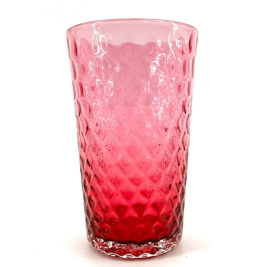 A red glass with a geometric pattern, crafted to resemble a pineapple optic design.