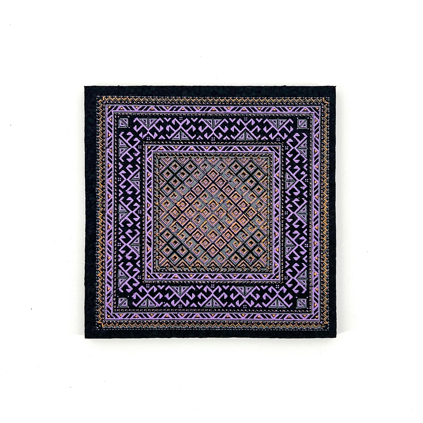 Decorative square mat with intricate patterns on a white background