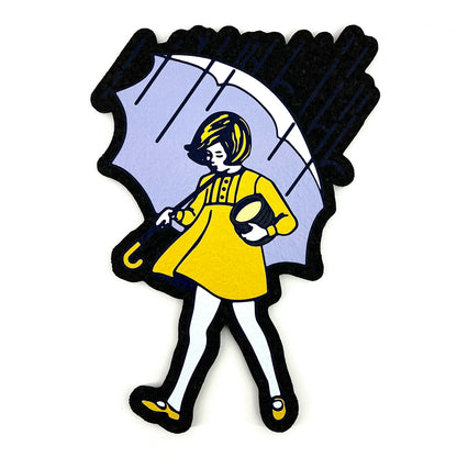 A moodmat featuring a graphic of a person in a yellow dress holding a black umbrella, with predominantly black and white colors.