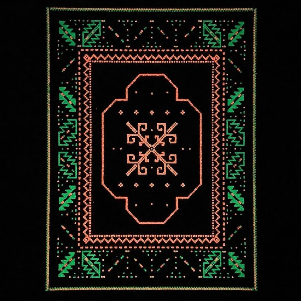 A rectangular 'High Roller Bitrug' mood mat with a geometric pattern featuring a central pink and black design, created with upcycled scraps.