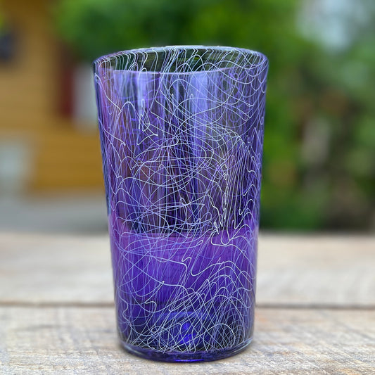 A purple glass with a swirling white pattern, crafted by Xander D’Ambrosio.