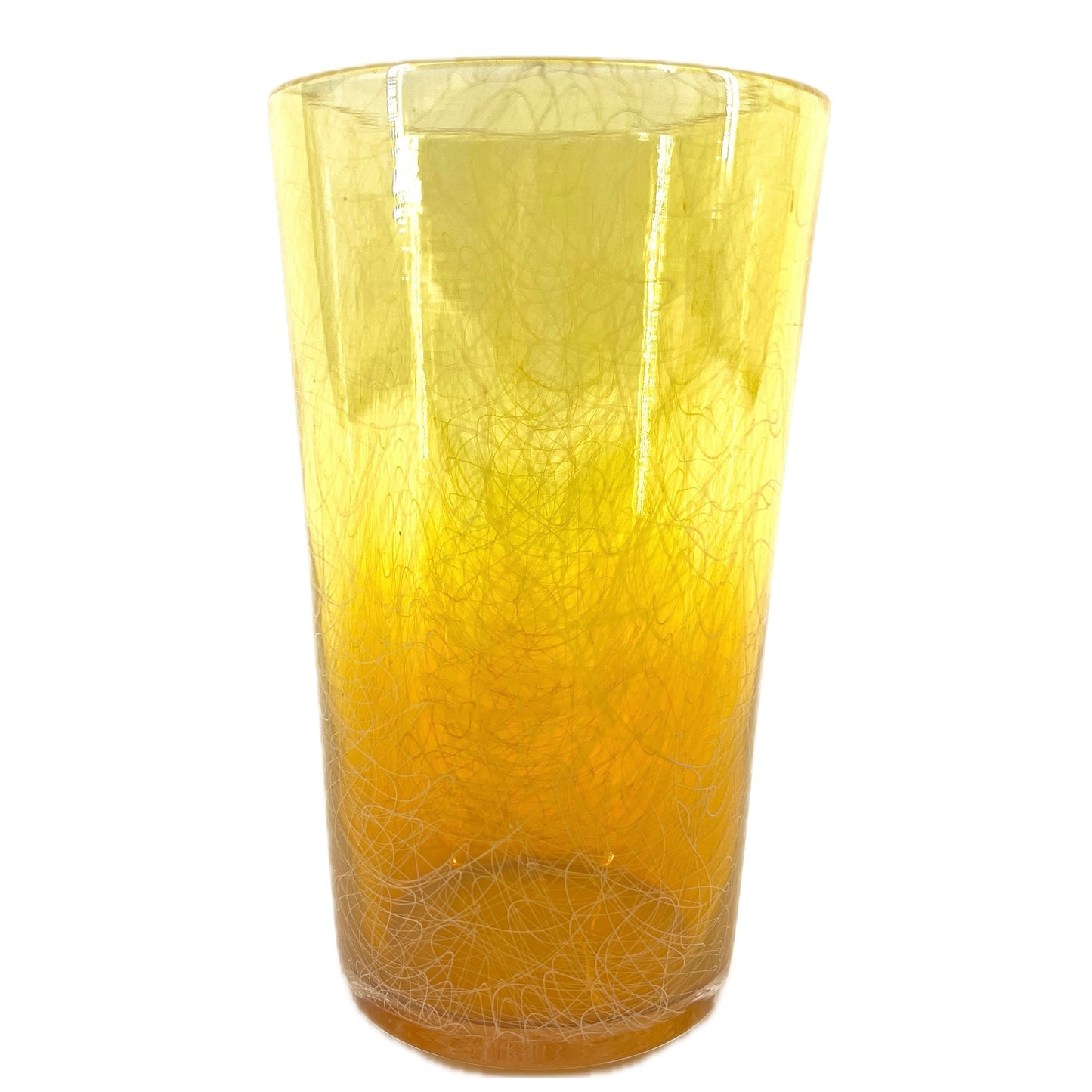 A cylindrical handcrafted glass with yellow and orange hues.