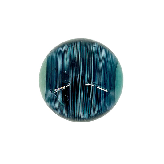 Round blue and black patterned marble on a white background.