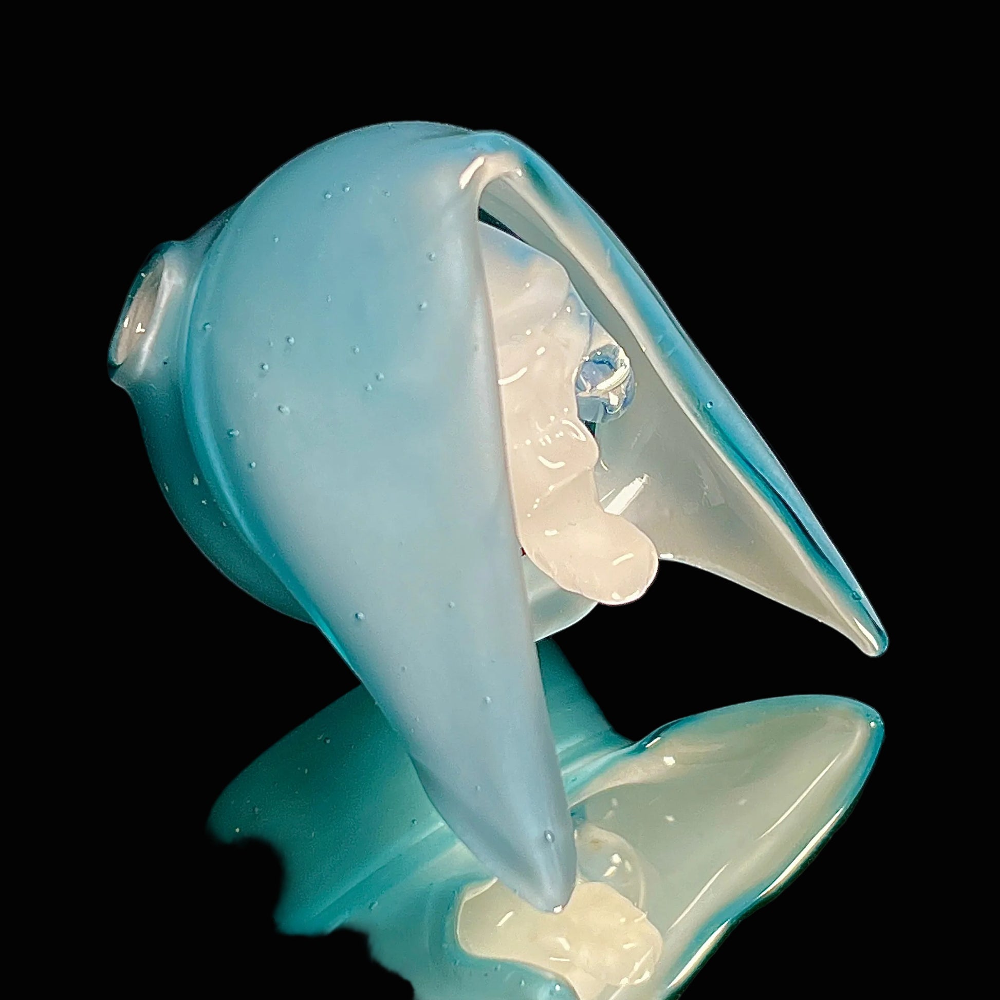 Blue glass reaper pendant with a black background.