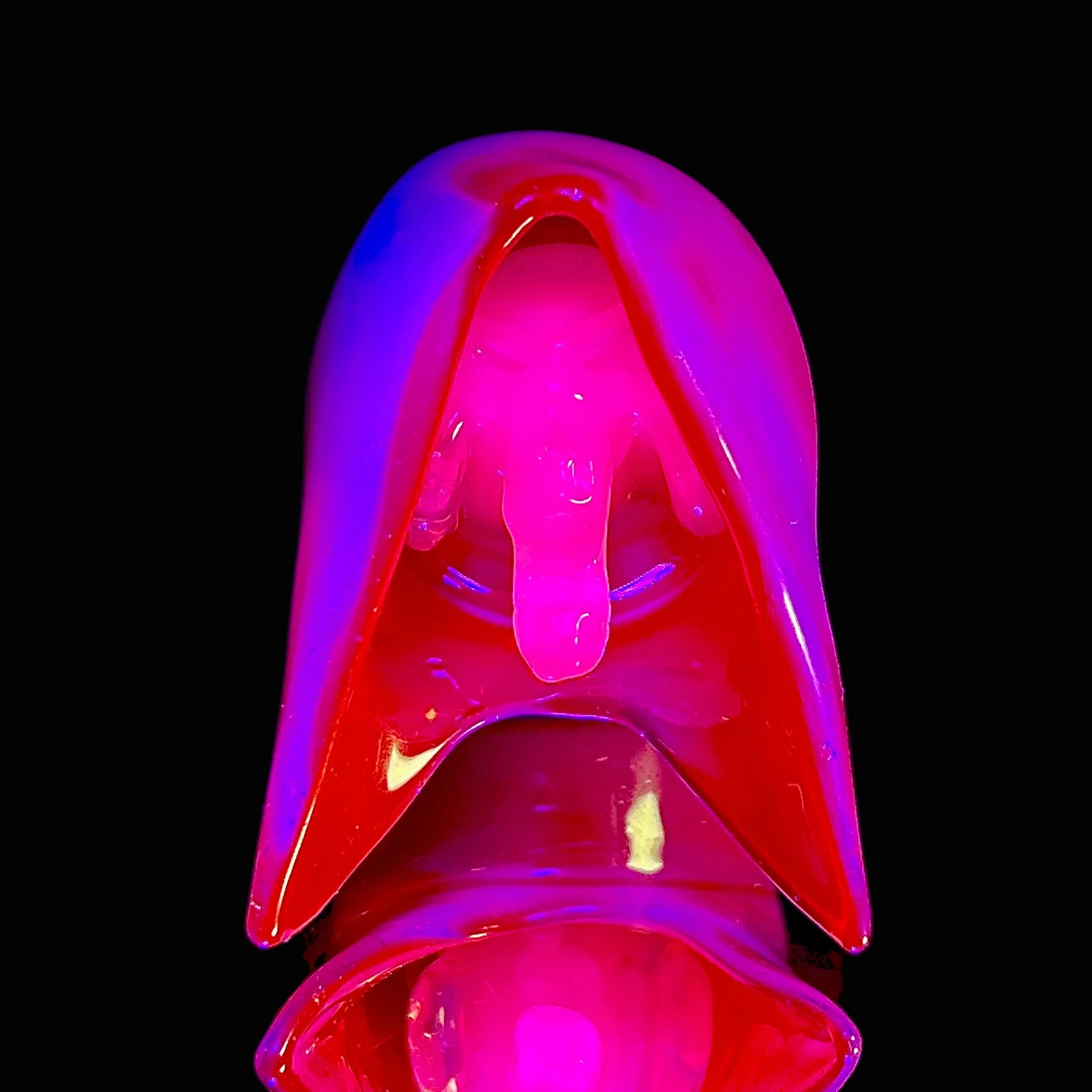 Glowing reaper pendant on a black background.