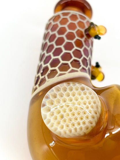 Glass pipe with a honeycomb design on a white background.