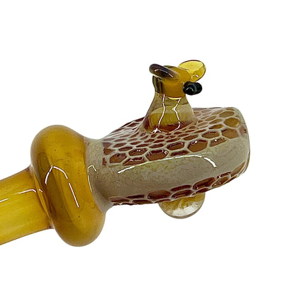 Glass pipe with bee design on a white background.