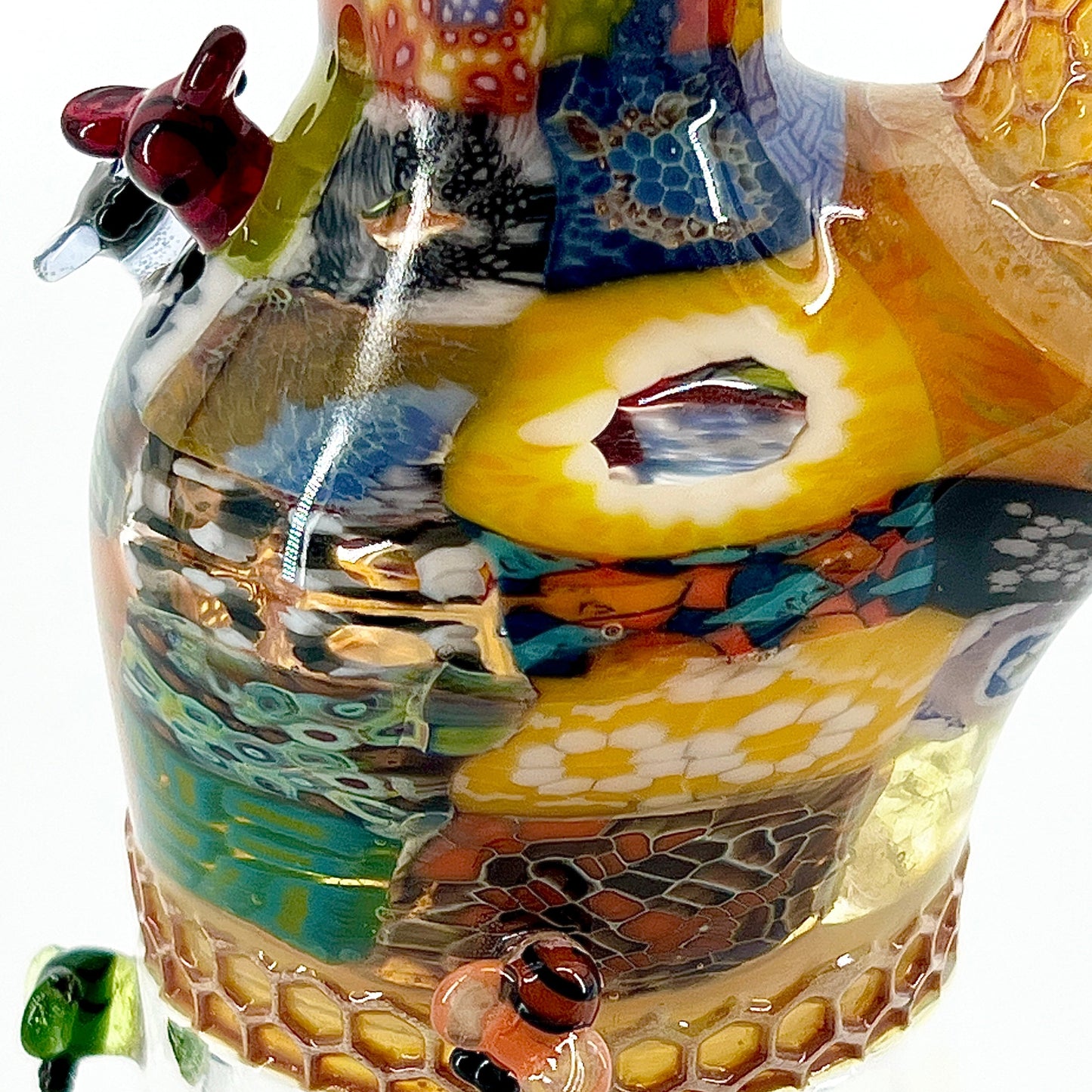 Colorful glass sculpture with honeycomb design on a white background.