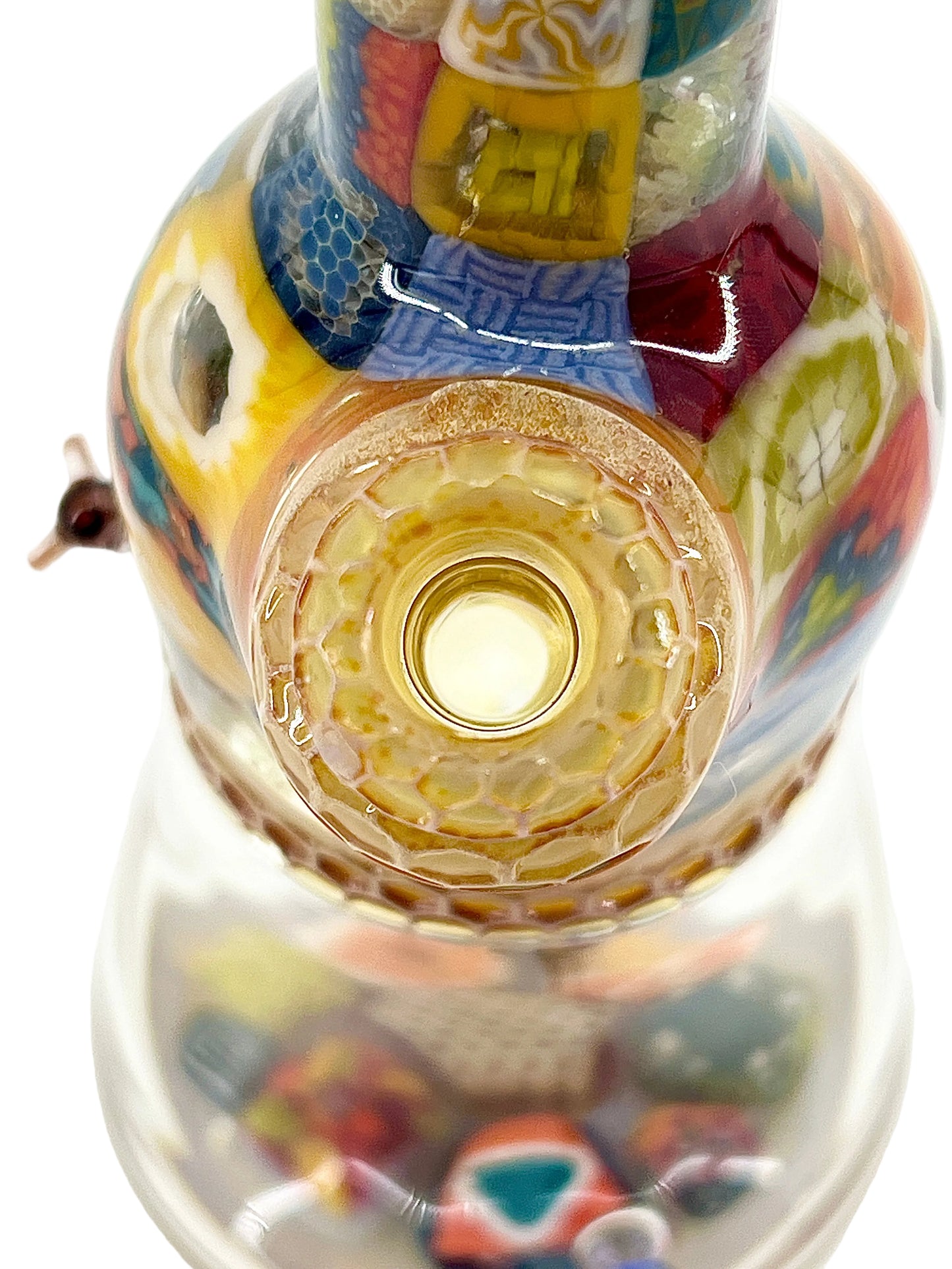 Close-up of a colorful glass object with intricate patterns on a white background.