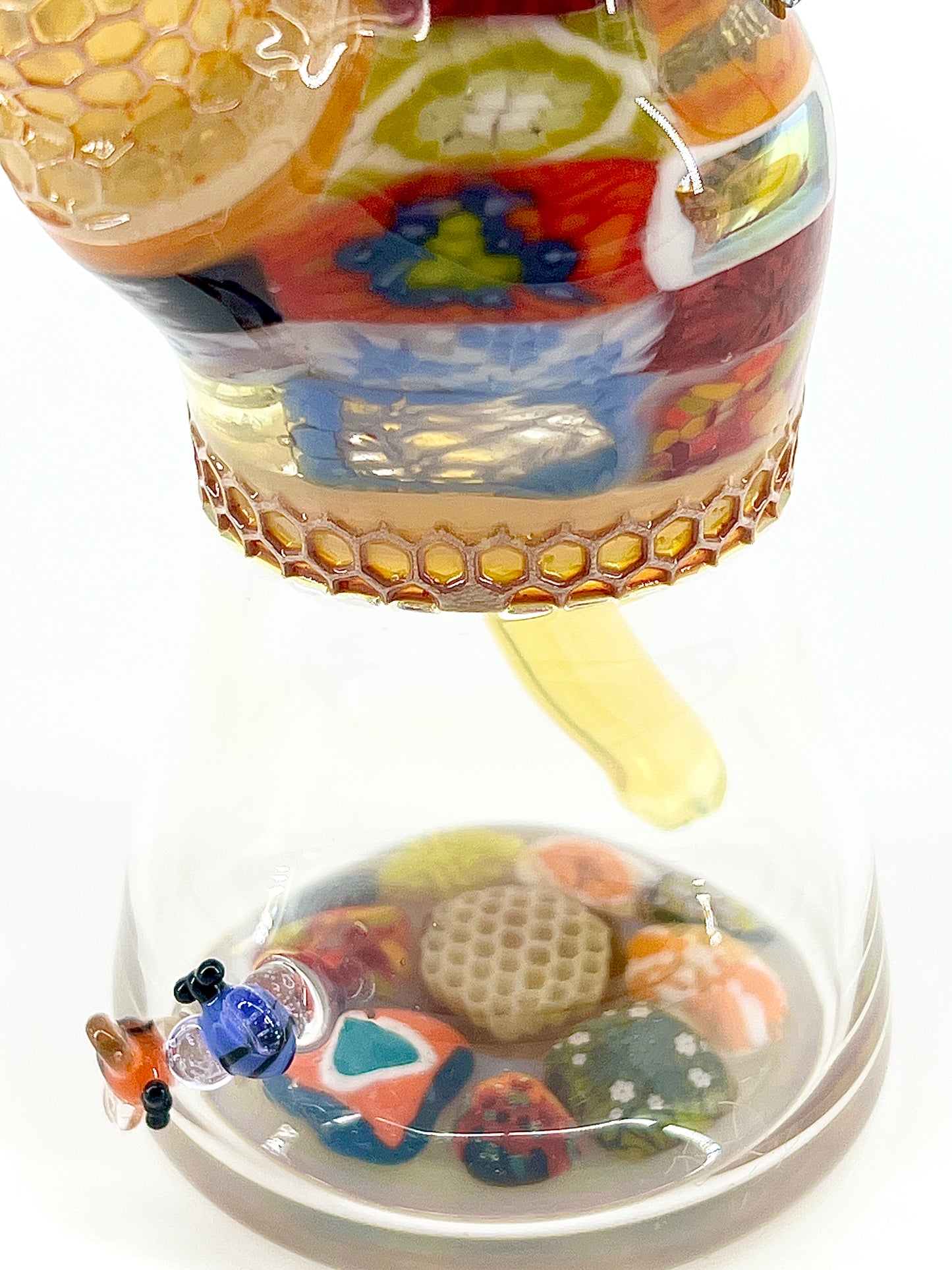 Colorful glass tube with floral design on a white background.