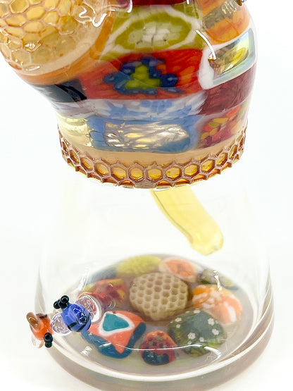 Colorful glass tube with floral design on a white background.