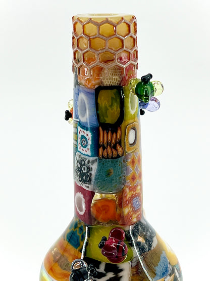 Colorful glass bottle with decorative patterns on a white background.