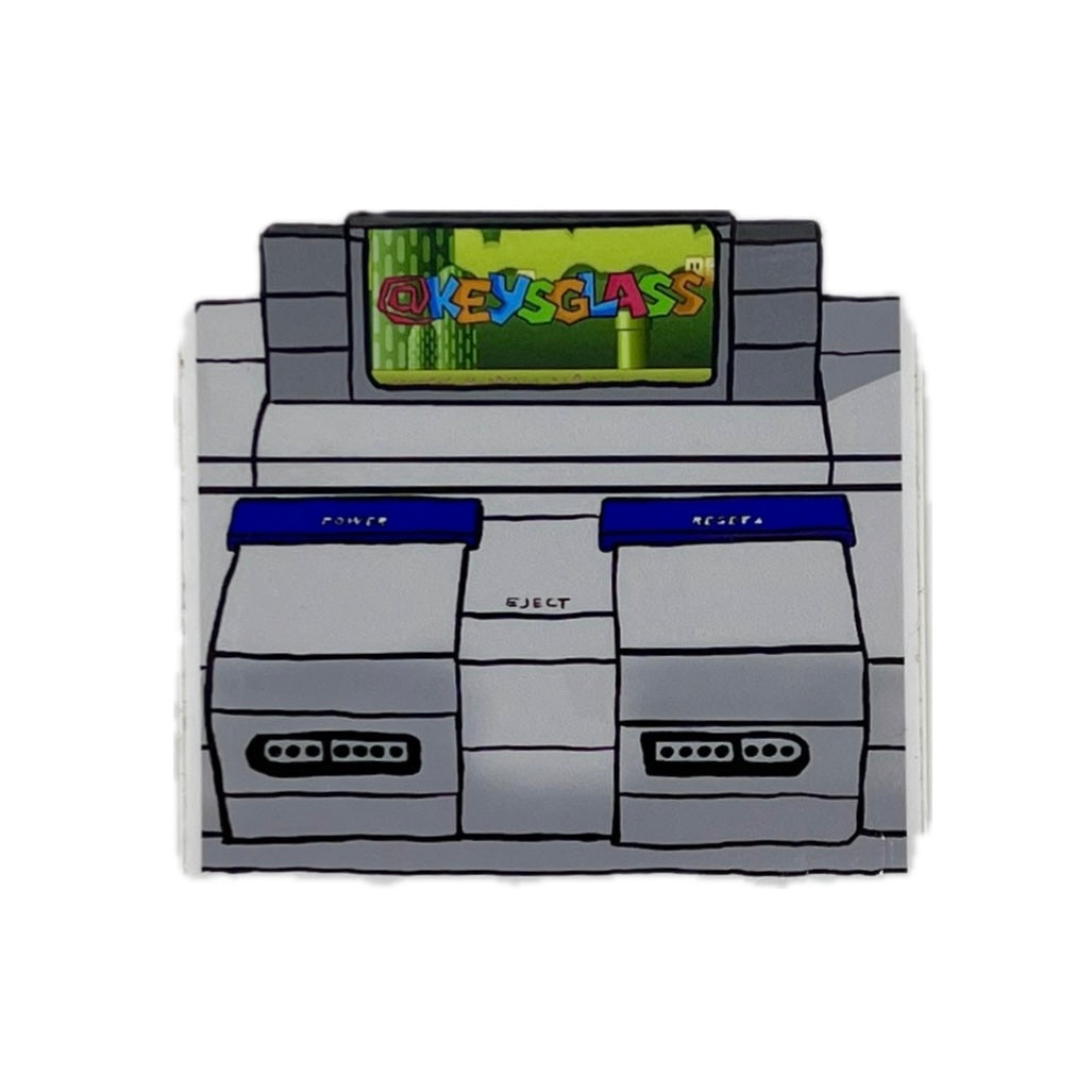 Sticker resembling a vintage video game console with a screen displaying 'OKYESGLASS'.