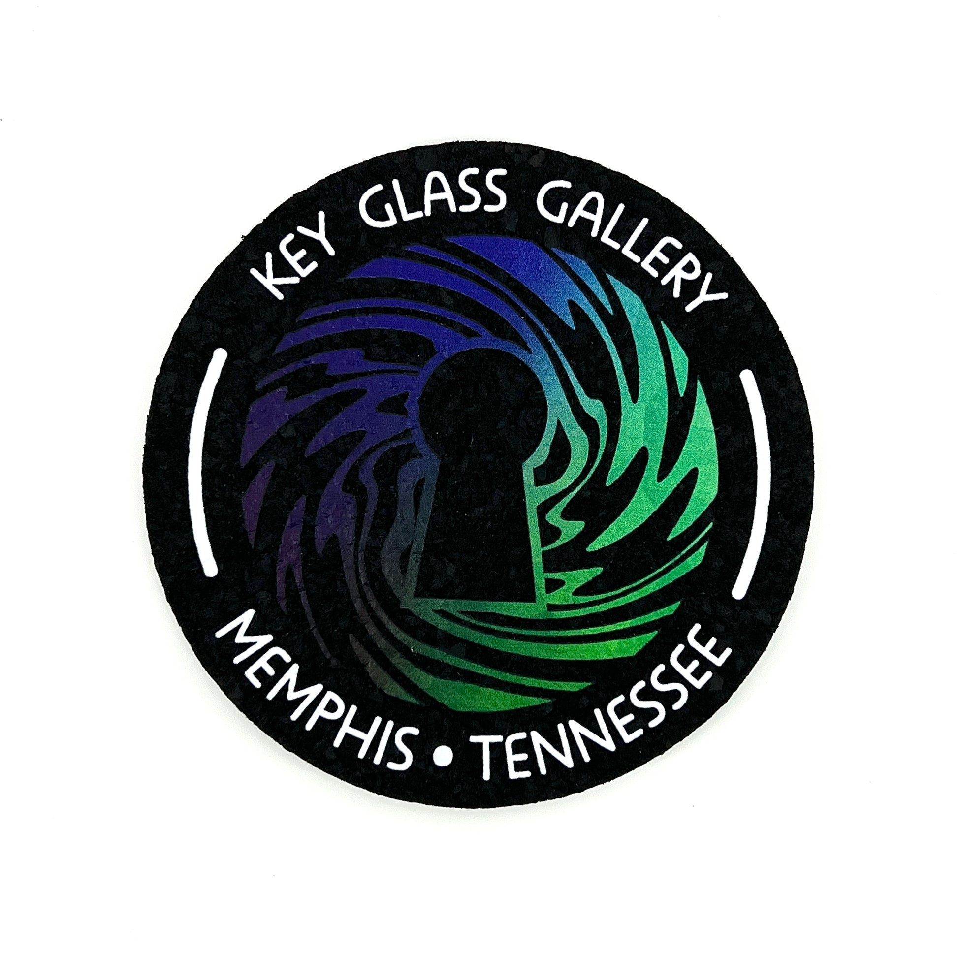 A round, flat, decorative moodmat with a graphic design featuring swirls and the text 'KEY GLASS GALLERY MEMPHIS TENNESSEE'. The background is black, and the text is in green and blue.