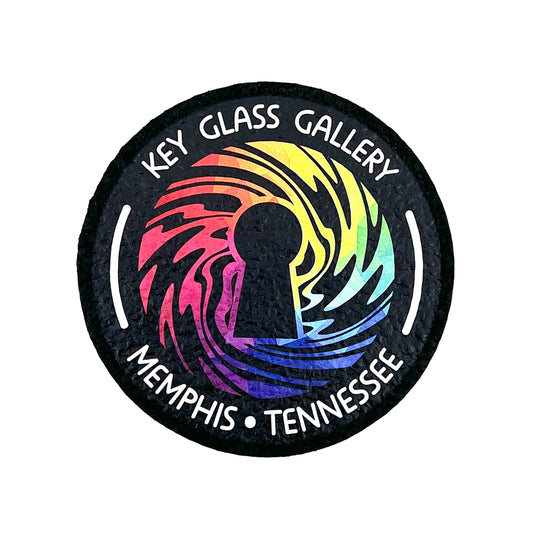 A round mat with a geometric design featuring a key and the text 'Key Glass Gallery Memphis, TN'.